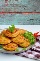 Perkedel, Indonesian fried potato minced beef patties garnish with parsley and chili in a bowl 