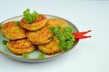 Perkedel, Indonesian fried potato minced beef patties garnish with parsley and chili in a bowl 