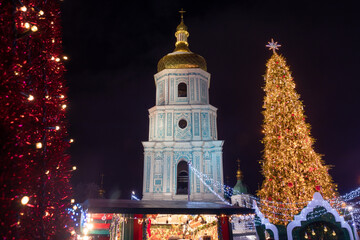 Fototapeta na wymiar Christmas tree and market at night city. Sophia Cathedral on background.