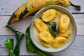 Indonesian Cuisine - Kolak Pisang or Plantain Banana Compote. Cooked with coconut milk, palm sugar and pandanus leaves. Ramadhan menu.