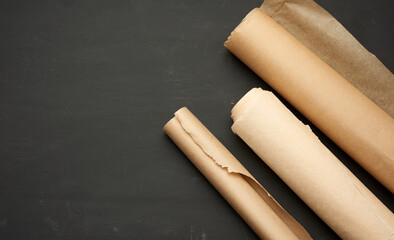 rolls of brown parchment paper on a wooden background
