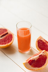 Grapefruit juice and ripe grapefruits on a white wooden background. refreshing drinks, grapefruit juice with rosemary and ice on a white wooden table.