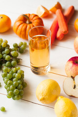 freshly squeezed juice, fruit and vegetable smoothies in glass glasses on a white table decorated with a composition of fruit