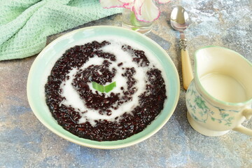 Indonesian traditional dessert: Bubur Ketan Hitam or black glutinous rice porridge with coconut milk sauce. Ramadan menu