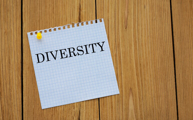 DIVERSITY - words on white paper attached to a wooden board
