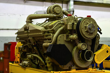 Large diesel engine with a huge turbine in the warehouse of finished products factory for the...
