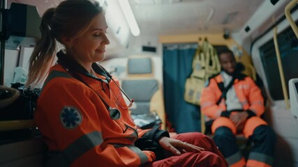 Calm and Happy Female EMS Professional Paramedic Mentally Prepares in Ambulance Vehicle on the Way to a Call. Emergency Medical Technicians are on Their Way to a Call Outside the Healthcare Hospital.