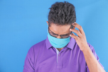 A young asian man with protective mask in face feeling sad 