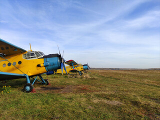 Parking yellow old piston aircraft biplanes with a propeller in the summer on the tarmac in Sunny...