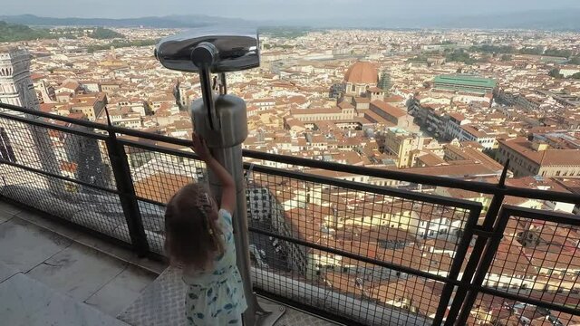 Little girl playing with binoculars on top of Santa Maria del Fiore dome viewpoint