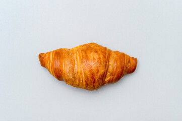 Fresh tasty croissant on grey background. French pastry