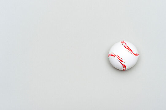Close up of baseball ball on grey background. Online workout concept.
