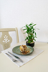 Pancakes with white chocolate and nuts on a plate, next to a knife and a fork. Breakfast concept. Eating at home.