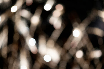 Blurry light bokeh stripes on a black background. Festive dark background.