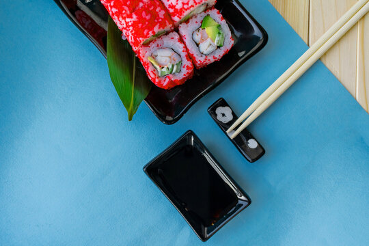 Set of sushi and maki on a blue background. Top view with copy space.