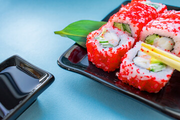 sushi on a plate with chopsticks on a blue background