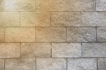 Background texture of a white brick or cement block wall in a commercial building with a ray of sun