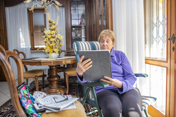 Elderly retired woman using tablet at home