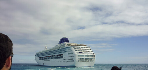 Modern Norwegian cruiseship or cruise ship liner anchoring at sea during Caribbean cruising to the...
