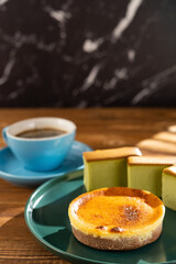 cheese cake with matcha cakes and cup of coffee at background in a sunny morning vertical composition