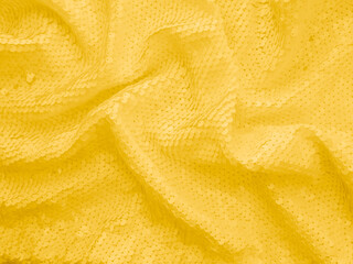 Photography of background fabric sequin in yellow color. Holiday abstract glitters with blinking...