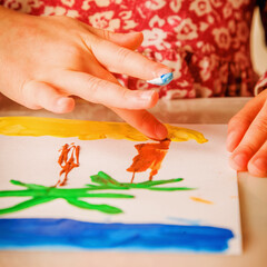 Close up child girl artist painting sea beach, home, palms and sun as symbol of dreams about summer holiday.