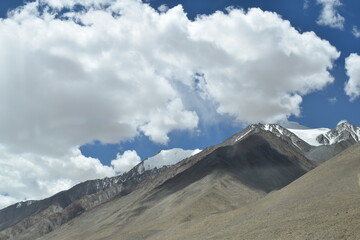 clouds over the mountains landscape with snow and mountains in the way of pangong lake