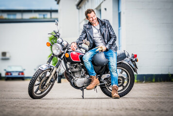 Fototapeta na wymiar cooler Mann sitzt auf einem Motorrad