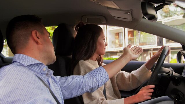 driver courses and people concept - woman and driving school instructor adjusting mirror in car