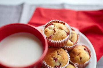 Strawberry muffin dessert with cup of milk on linen napkin background