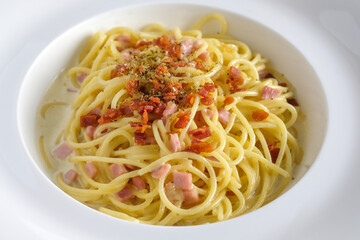 Spaghetti carbonara with bacon on white dish