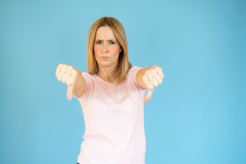 Portrait of displeased woman who is showing thumbs down