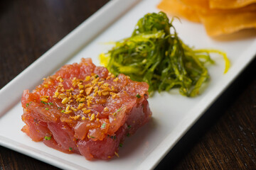 Tuna tartare. Classic American restaurant or bistro appetizer classic. Sushi grade ahi tuna, diced, mixed w/ eggs, red onions, olive oil, lemon juice, garlic & capers. Served w/ garlic bread.