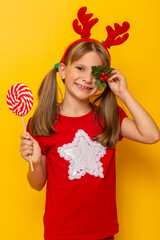 Little girl holding big lollipop and a mistletoe