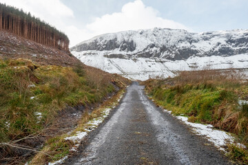 Small asphalt road leads into mountains covered with snow. Nobody. Gleniff Horseshoe Drive, county Sligo, Ireland