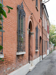 Fototapeta na wymiar Ferrara, Italy. Old stately home, facade. Windows with elegant railings.