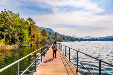 Avigliana, Italy. October 10th, 2020. Woman walks on the jetty of the lake in a autumn day.