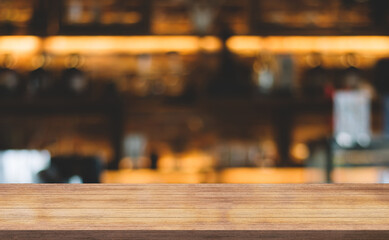Empty wooden table top with lights bokeh on blur restaurant background.