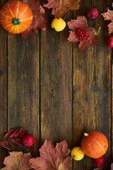 Autumn background with yellow maple leaves, red apples and pumpkins. Frame of fall harvest on aged wood with copy space. Mockup for seasonal offers and holiday post card, top view