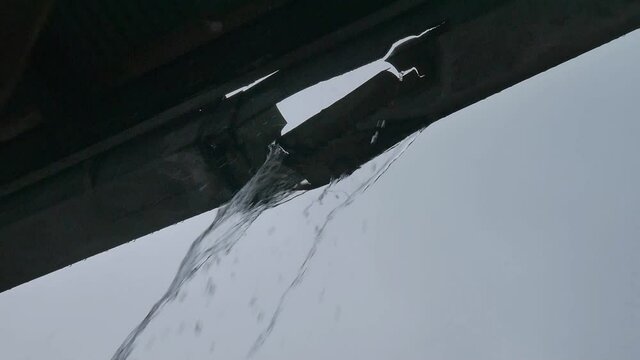 Broken gutter. House guttering leaking gallons of rain water flooding