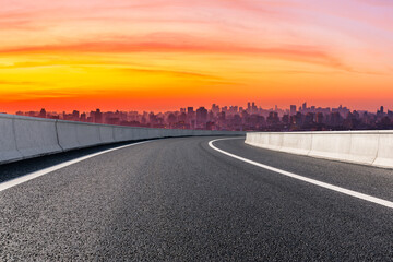 Empty asphalt road and city skyline with buildings in Hangzhou at sunrise.