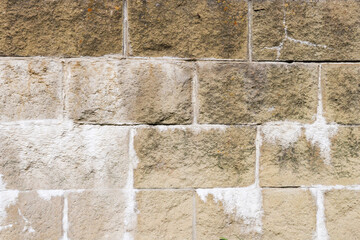 Old block gray-brown wall with embossed texture and volumetric pattern on a decrepit surface