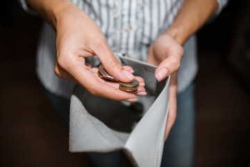 Obraz premium Woman counts money, a close-up of a purse with ruble coins. The concept of bankruptcy, income decline, job loss. Selective focus, dark background