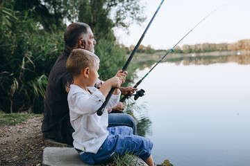 grandfather and his grandson fishing on the lake