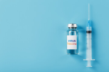 Syringes and ampoule with the vaccine against the Virus from diseases on a blue background.