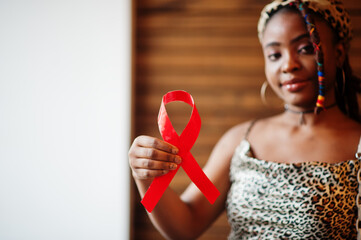 AIDS awareness. Stylish african american woman hold red ribbon.