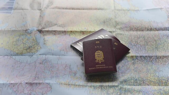 Passports and various currencies in a plastic bag being thrown on a colourful map of Europe. The most of Europe is in the frame. Short clip to illustrate traveling and tourism. Slow motion 1080p stock
