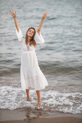 Fototapeta na wymiar beautiful woman in white dress by the sea