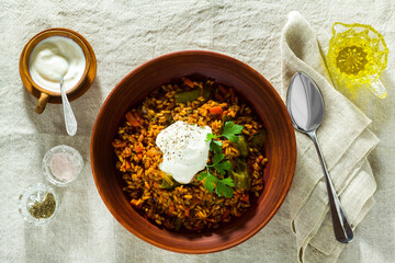 rice with vegetables and yogurt. in earthenware on a linen tablecloth