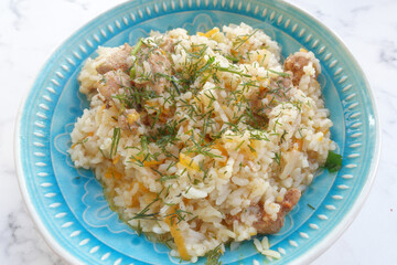 pilaf is a national dish. Rice with meat and fresh herbs is on the table, ready for a delicious dinner